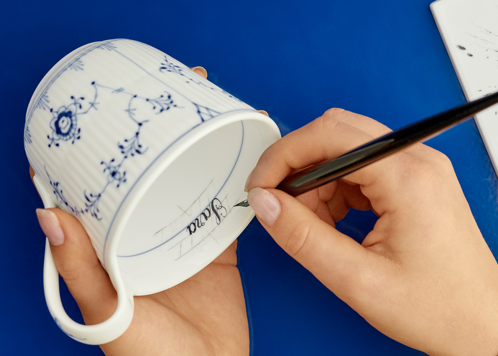 Få håndmalet konfirmandens navn eller initialer på en af vores kopper med Royal Copenhagen Bespoke.